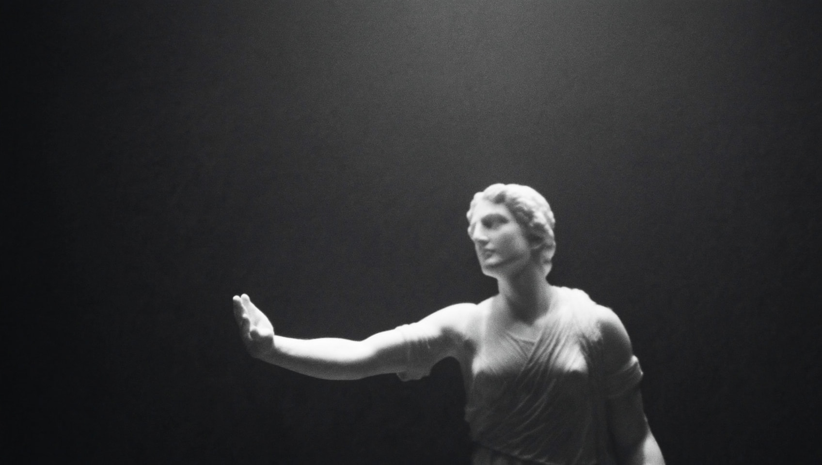 Classical marble figure emerging from darkness